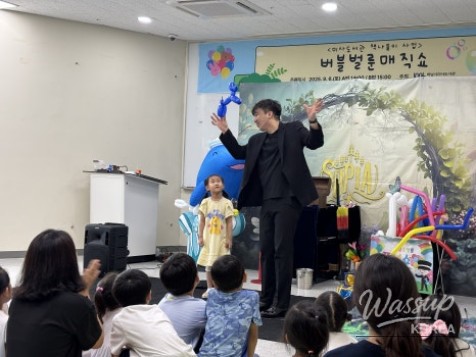 Magician smiling and engaging with children during a birthday party