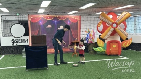 A magician creating custom animal-shaped balloons for children at a party