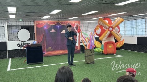 Magician showing a card trick to an amazed group of kids