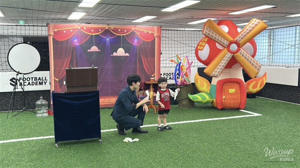 Wide view of the audience captivated by the magician's stage presence