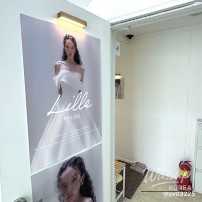 Bride trying on a luxurious beaded wedding dress in a brightly lit fitting room