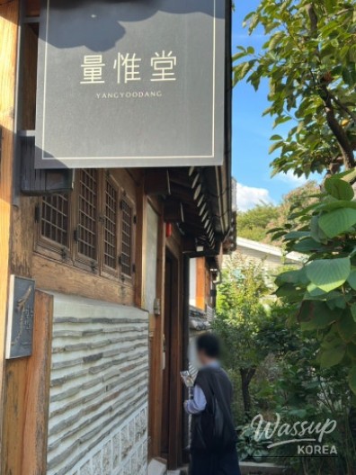 Close-up of a traditional broom attached to the Hanok wall symbolizing good fortune