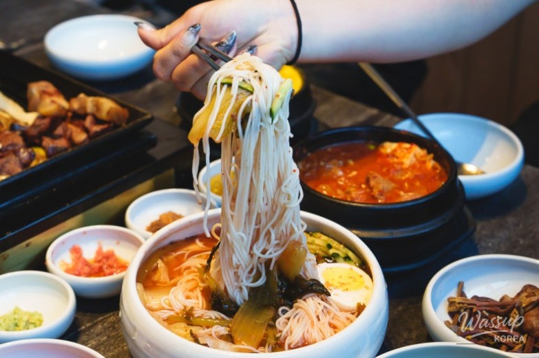 Grilled mushrooms and kimchi accompanying the pork