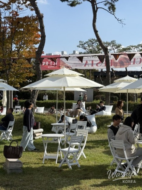 Choi Byeol hosting a talk show on the Brunch Festa stage surrounded by an attentive audience