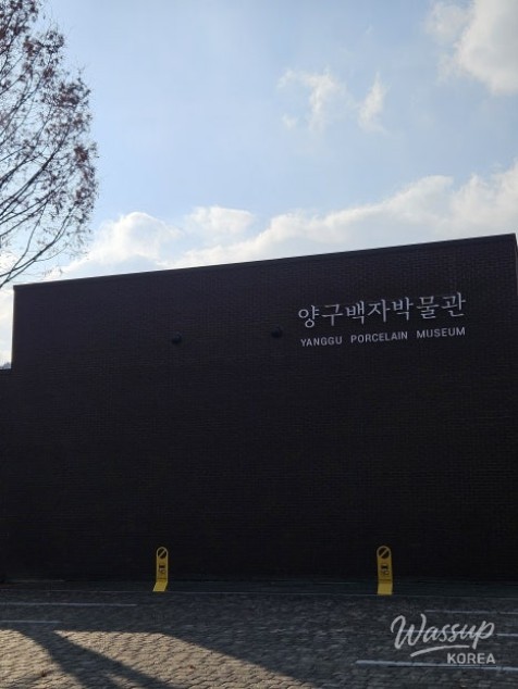 Outdoor porcelain sculptures and white birch trees standing in the snow at the museum park