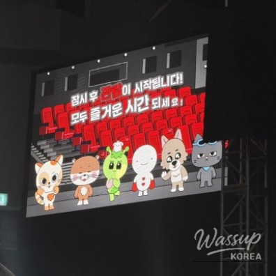 Showcase crowd atmosphere with stage lights and winter coats