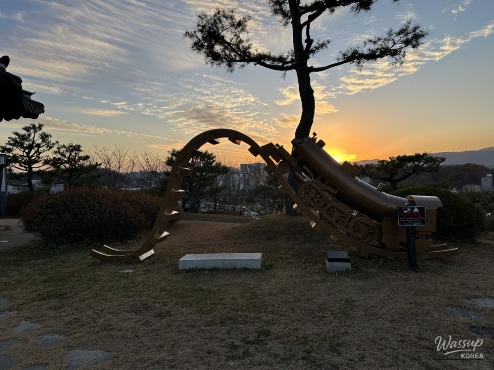 Soft sunset light surrounding Buyeongdae pavilion and nearby park area