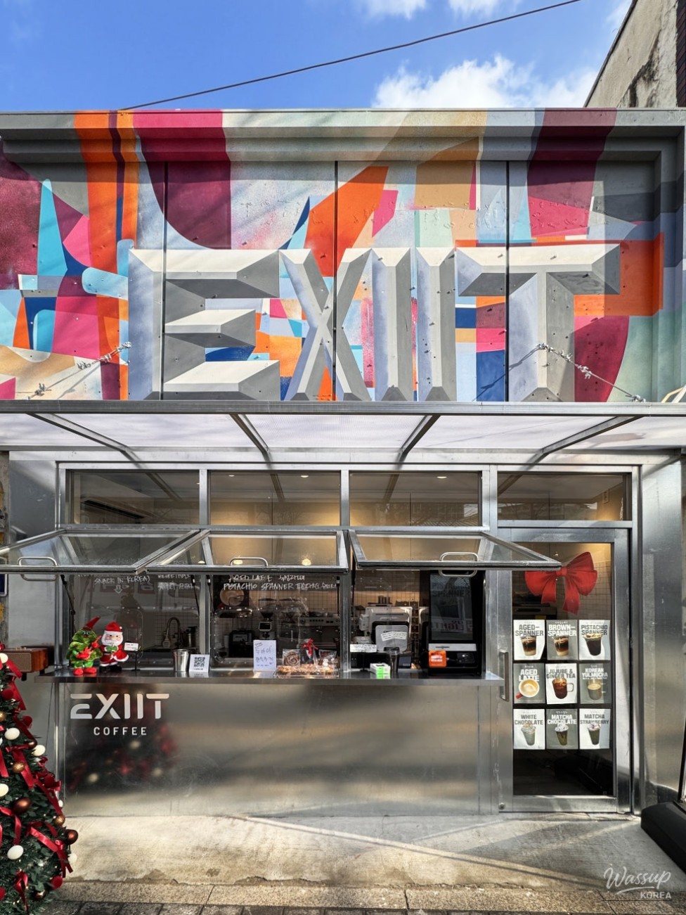 Exterior view of Exit Cafe with bold graffiti sign near Uraeok