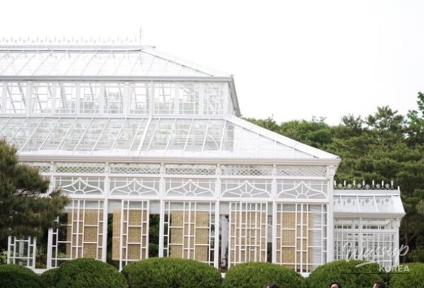 Exterior view of the Changgyeonggung Great Greenhouse contrasting with traditional palace buildings