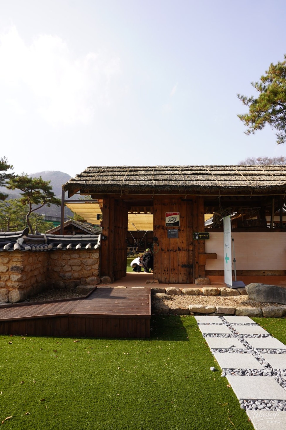 Traditional farming artifacts and wooden structures displayed in the outdoor park