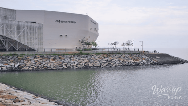 The iconic Red Lighthouse of Oido standing against a colorful sunset