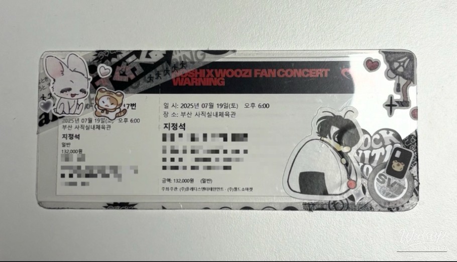 Vibrant pink nails held up against a concert background