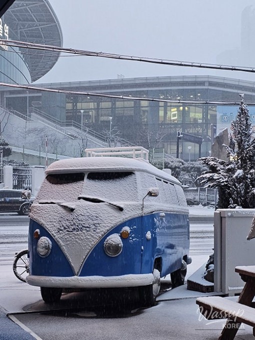 A large and adorable Chunsik snowman created by baristas during a snowy day in Seoul