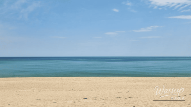 A peaceful sunrise scene at Songjeong Beach with the breakwater in the distance