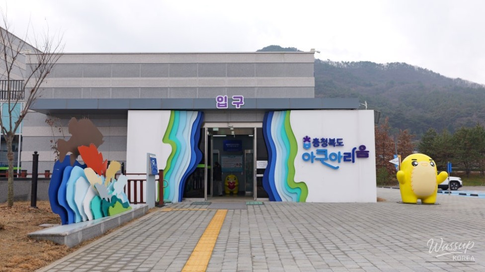 Children observing freshwater fish through low-level transparent viewing windows