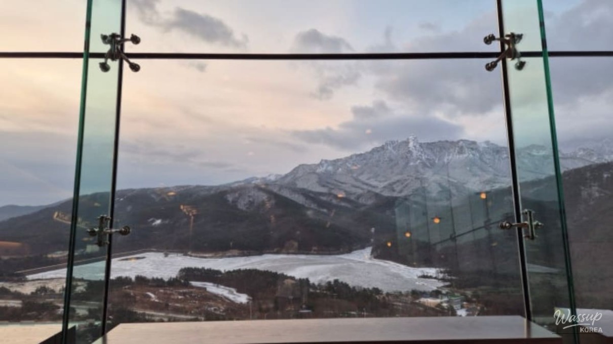 Panoramic view of the snow-covered Ulsan Rock from the floor-to-ceiling windows of The Ambrosia cafe