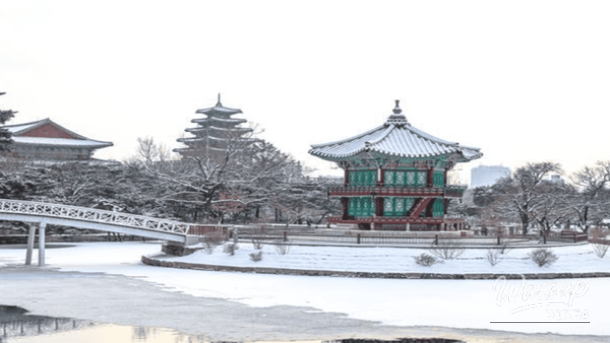 Hyangwonjeong Pavilion at Gyeongbokgung Palace surrounded by a serene snowy landscape