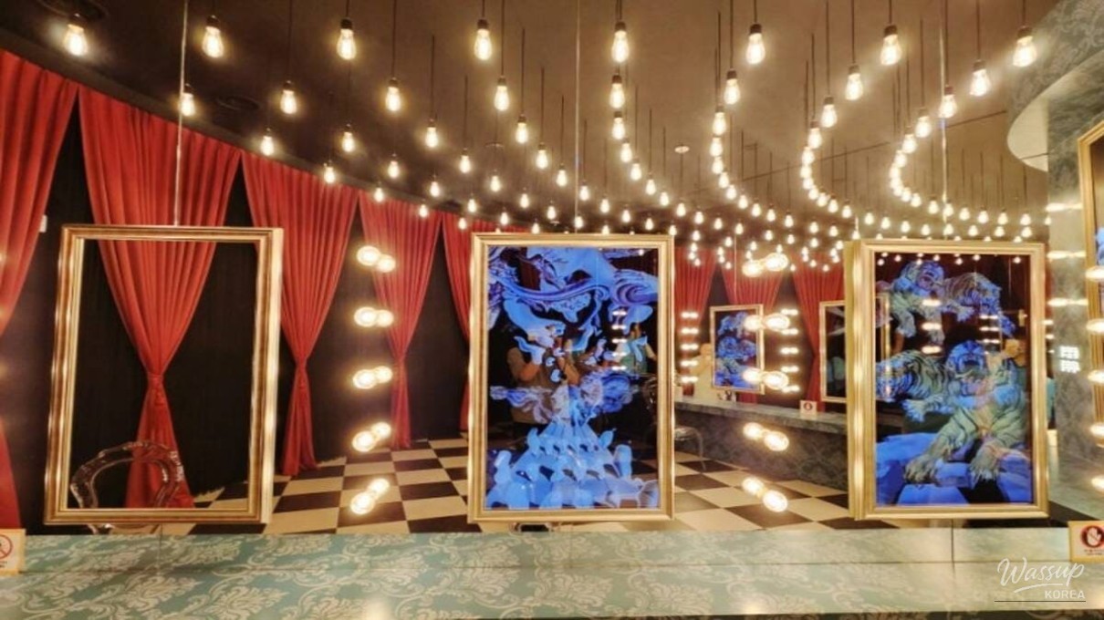 A visitor observing the artwork from the suspended bridge at Théâtre des Lumières
