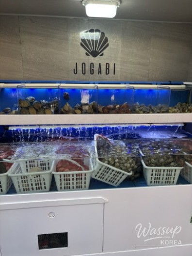 Fresh clams and seafood in tanks at the entrance of Jogabi Myeongdong