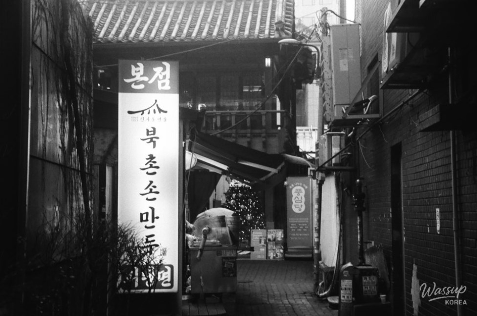 People walking up the sloped path of Ssamzigil framed by artistic lighting