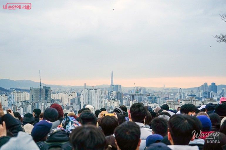 The sun rising over the Seoul city landscape with the Lotte World Tower in the distance