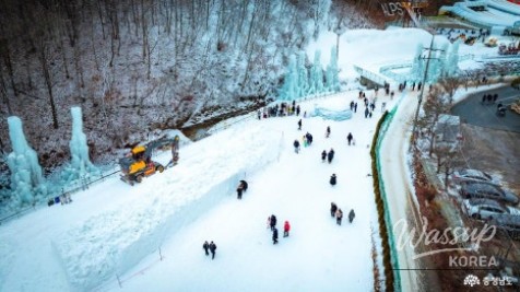 Ice castle and igloo photo zone glowing under winter light at the festival