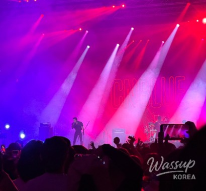 Festival crowd reacting to a headline performance as the stage lights fill the night