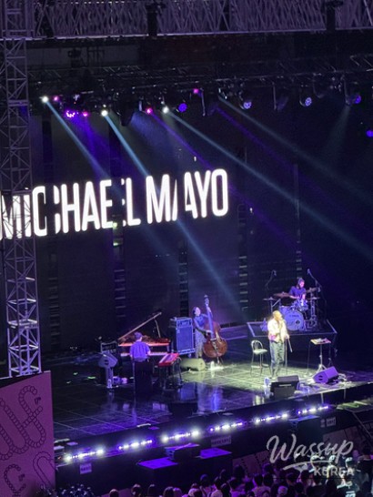 Wide-angle festival scene showing the crowd gathered near the main stage