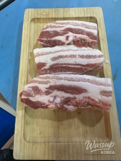 Friends gathering around a grill at Ibaekjeom Meat Restaurant in Ikseon-dong