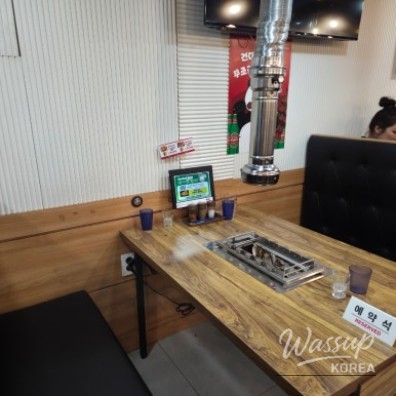 Large portion of whole lamb ribs being grilled over charcoal at Tenten Yang Kkochi