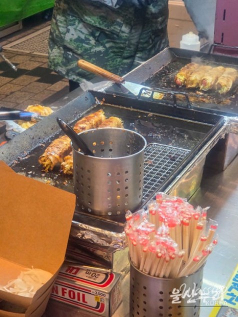 Warm street food stalls and shared dining tables at the Ulsan night market