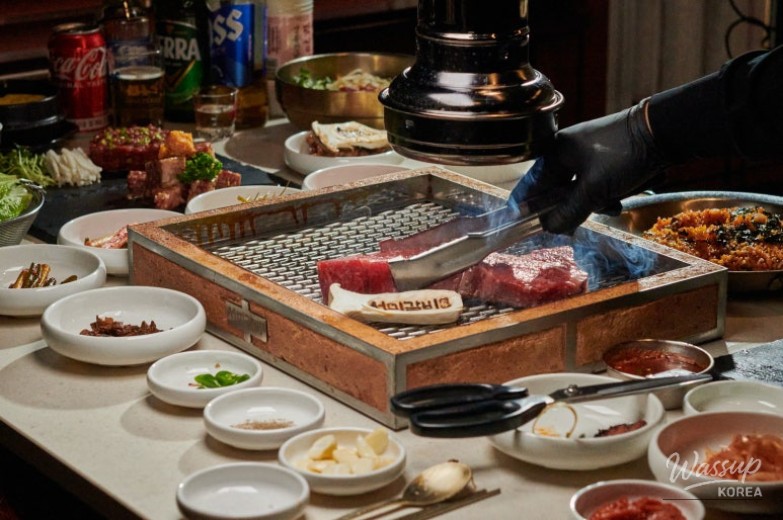 Side dishes and fresh vegetables served with grilled meat at Seomi Galbi