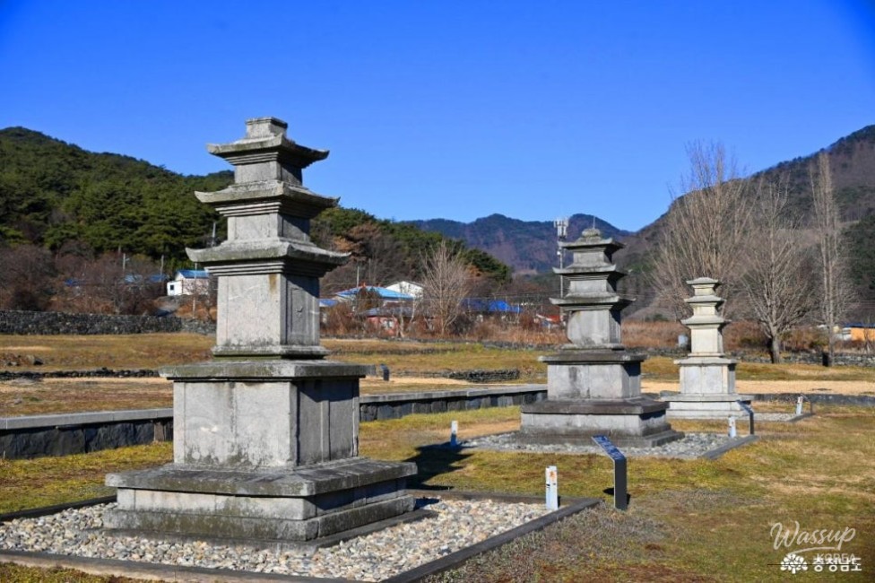 Stone Buddha statue and three stone pagodas arranged at the Seongju Temple Site