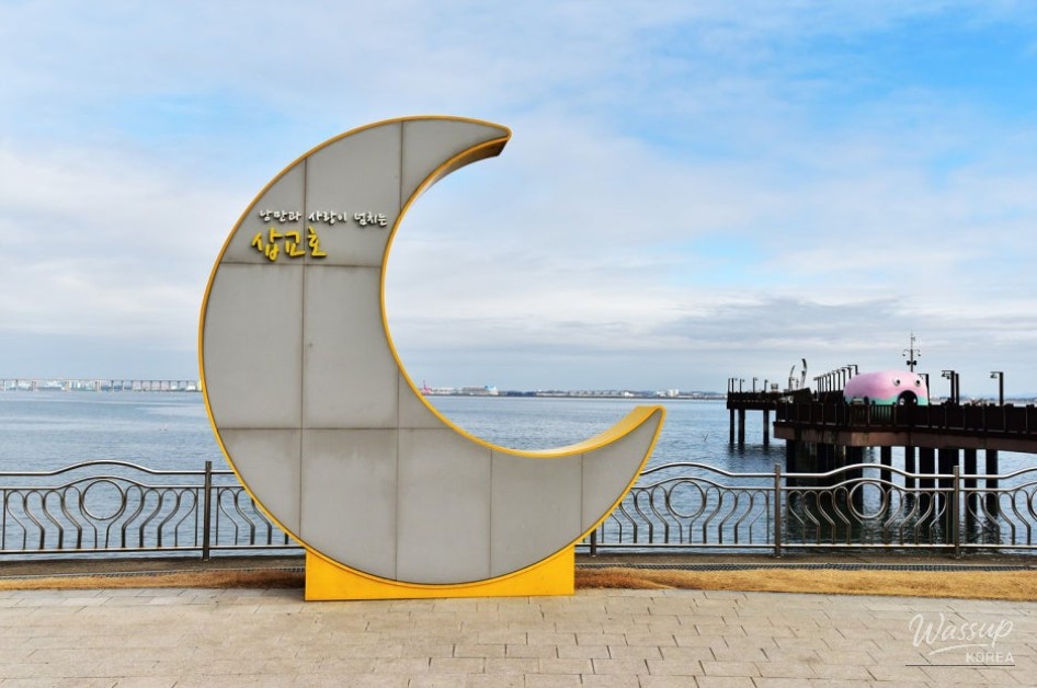 Seagulls flying near the seaside square with visitors feeding them at Sapgyoho
