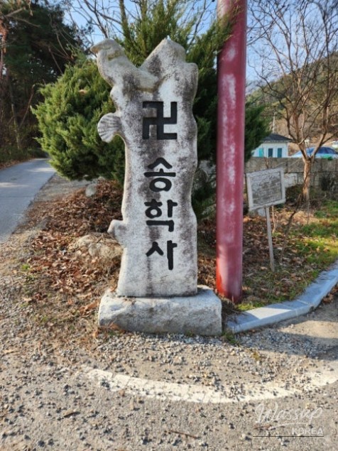 Main hall of Songhaksa Temple featuring Buddha statues and traditional murals