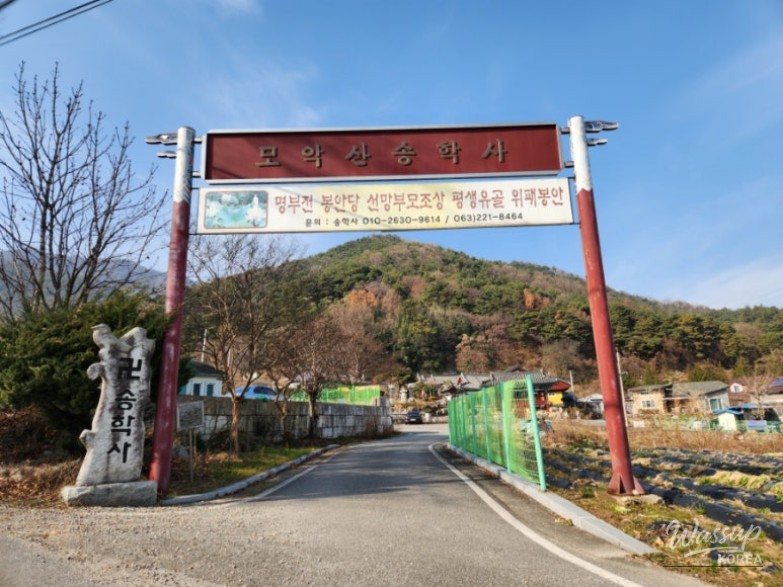 Upper area of Songhaksa Temple with stone Buddha, lotus pond, and mountain shrine