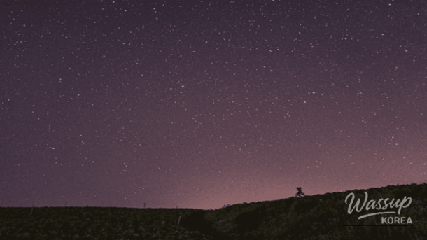 Quiet winter beach at Hwa Jin Po with stars reflecting over the sea under a dark sky