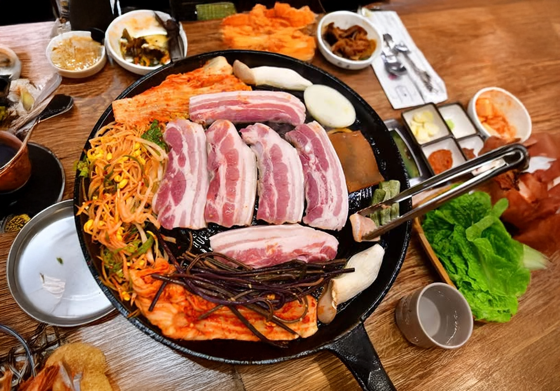 Thick Jeju black pork cuts on lid grill at Myungga Sotttukkeong