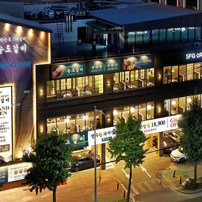 Succulent marinated pork ribs grilling on a charcoal fire at Songdo Galbi