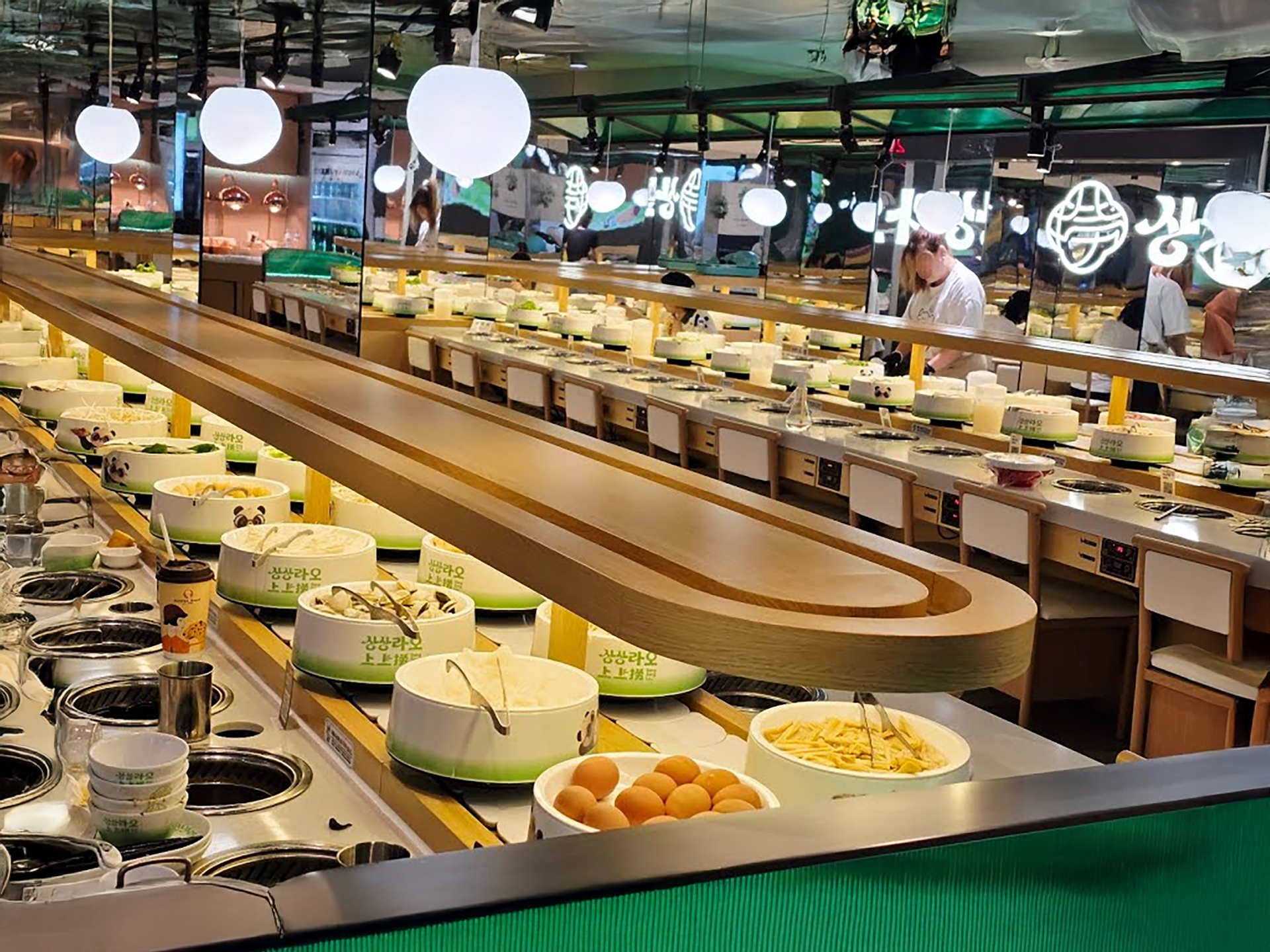Vibrant revolving hot pot conveyor belt with fresh ingredients at Sang Sang Lao Konkuk University
