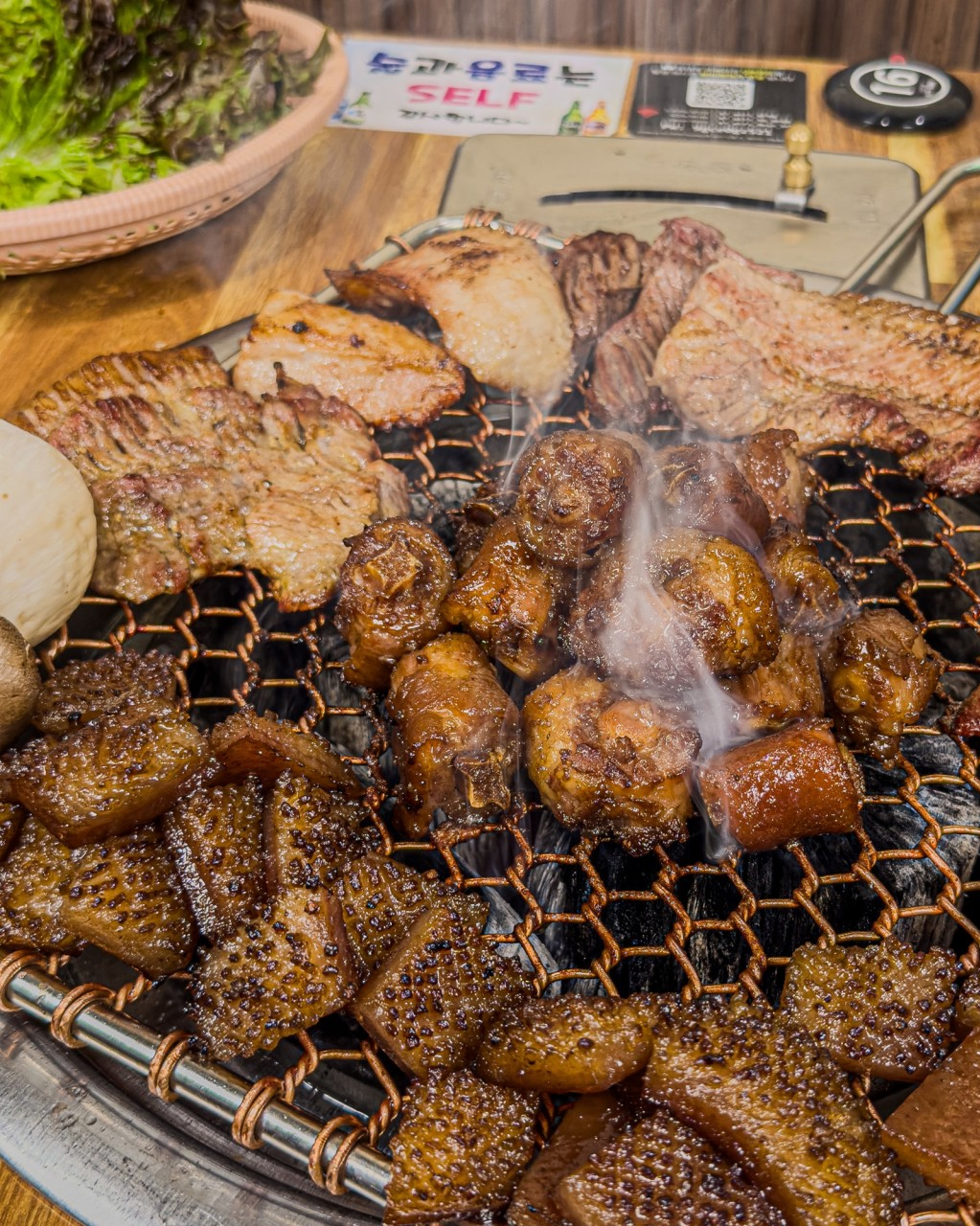 A full table set with various side dishes, fresh vegetables, and dipping sauces at Chotukgeup
