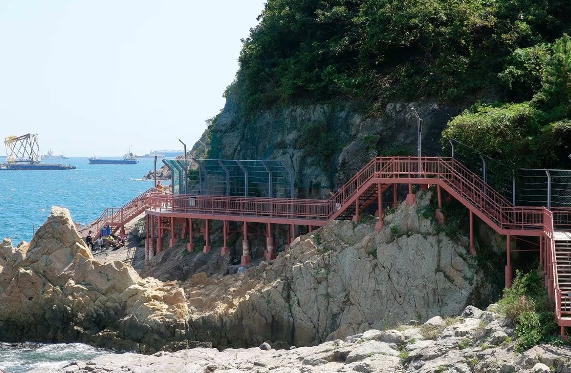 Rock formations and walking path along Songdo Coastal Walkway
