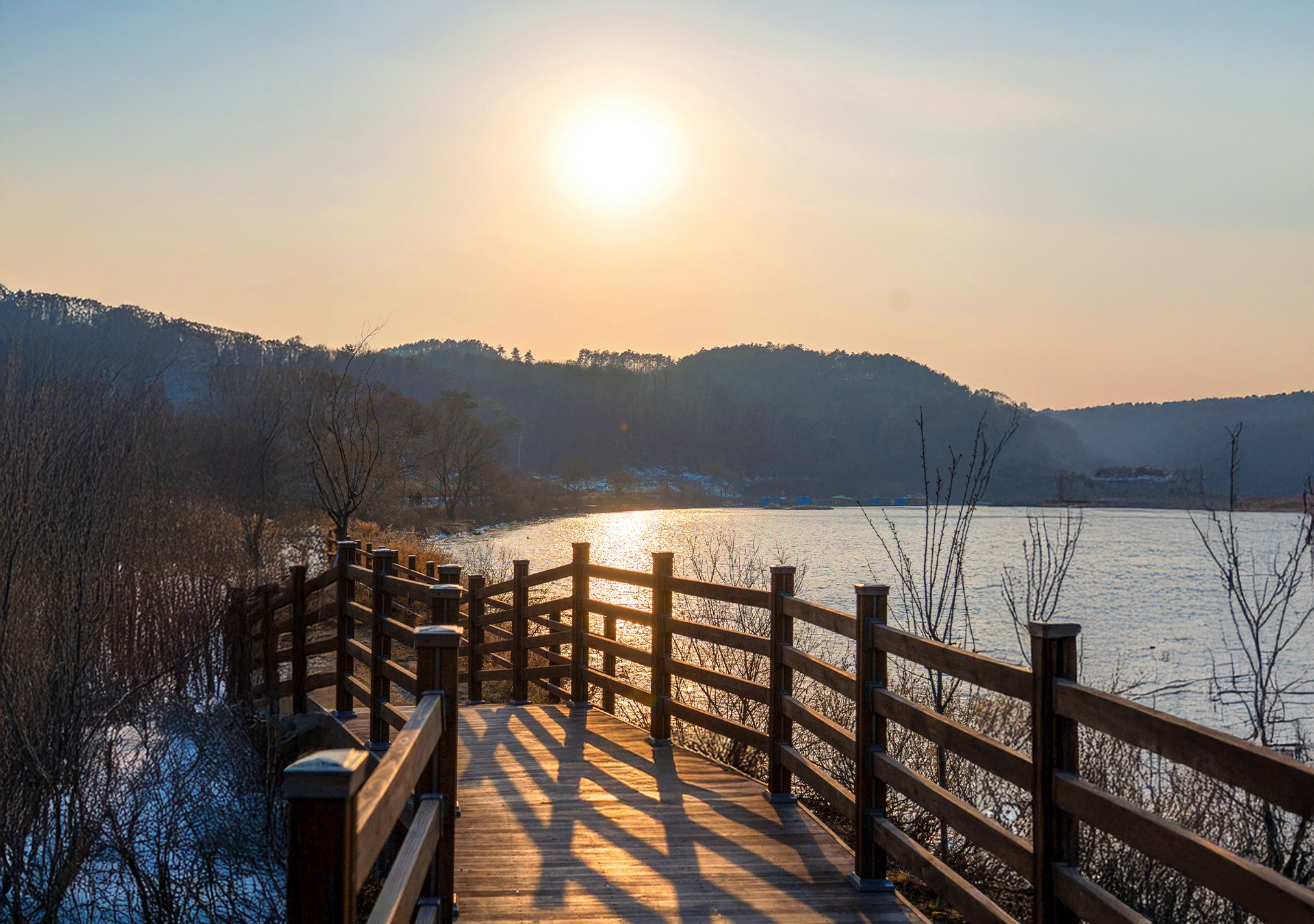 A quiet lakeside walking path at Yongdeok Reservoir featuring a wooden deck and peaceful atmosphere