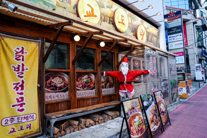 Cozy and lively interior atmosphere of a Sangsu pocha with customers dining.