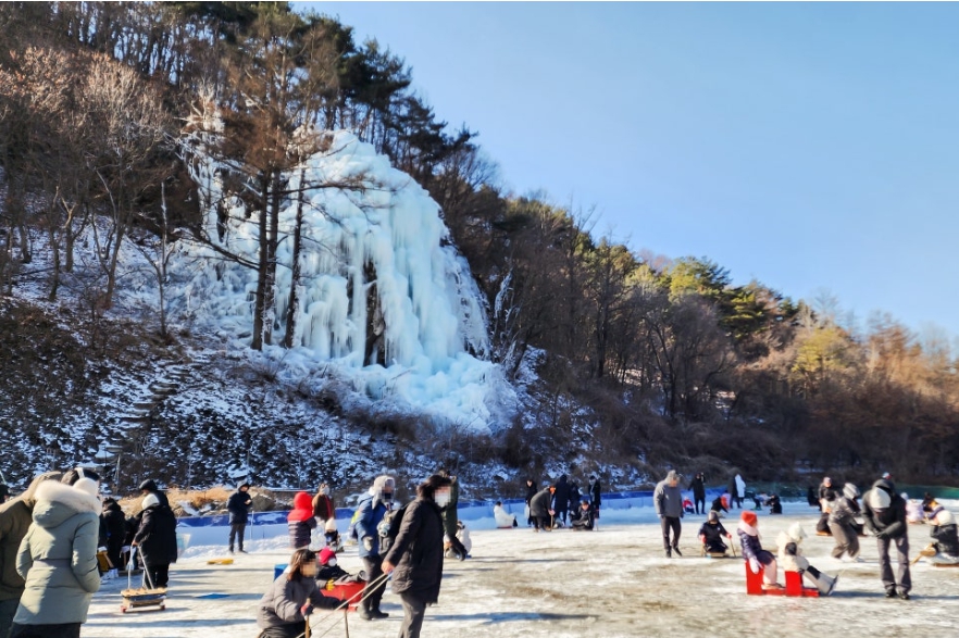 Festival visitors enjoying winter activities despite the cold weather.